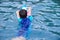 Back view of asian boy with kick board and ball in pool. Outdoor