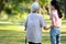 Back view of asian child girl hand holding her senior grandmother, walking together outside home,family time,old elderly taking a