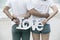 Back view of asian couple holding love sign standing in sea on h