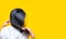 Back view of Asian woman holding damaged hair on yellow background. Hair loss and thin hair problem in woman. Dry and brittle