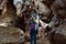 Back view of asian woman traveller walking in the cave to explore cave with stalagmites and stalactites.