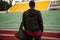 Back view of a athletic man with bag standing at the stadium