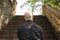 Back view of a bald beefy Caucasian man standing in front of the stairs. Unidentified incognito person concept