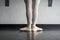 Back view of ballet dancer ballerina at the barre in dance class standing in first position