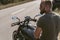 Back view of a bearded biker sitting on his motorcycle