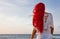 Back view of a beautiful red haired woman enjoying the sunset at the beach