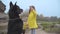 Back view of big black doberman standing on hind legs asking for snack. Cute Caucasian girl in yellow coat giving food