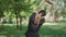 Back view of blond mid-adult sportswoman in black cap and T-shirt raising hands up and bending. Slim Caucasian woman