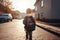 Back view of a boy with a backpack walking on the street. Cute little primary school students full rear view, AI Generated