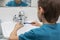 Back view of boy cleaning his dental orthodonic plates with  toothbrush.