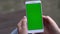 Back view of brunette holding chroma key green screen smartphone watching content Gadgets and contemporary people