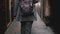 Back view businesswoman with backpack wearing fashionable suit walking along dark street in Venice, Italy slow motion.