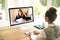 Back view of businesswoman talking to her colleagues about business plan in video conference