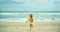 Back view carefree woman in hat running to sea water, enjoying on beach,