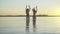 Back view of charming slim Caucasian tanned women dancing in river at sunset. Extreme wide shot of joyful young female