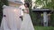 Back view of cheerful African American gorgeous bride in white dress looking back at guests turning and throwing bridal