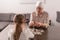 back view of child with sick grandmother in kerchief playing with jigsaw puzzle together