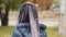 Back view close-up lonely child in amusement park little girl with pigtails standing outdoors baby turning head close-up