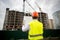 Back view of construction engineer looking at plan of building