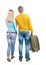 Back view of couple with green suitcase looking up.