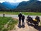 Back view of couple of motorcyclists adventure riders. Green meadow in Zgornje Jezersko, to Kamnik-Savinja Alps on a sunny summer