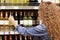 Back view of curly woman chooses wine on shelf in supermarket, prepares for holiday or special day, makes purchase. Wavy cute youn