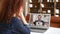 Back view curly woman talking with diverse motivated workteam on the laptop screen