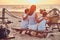 Back view of a cute family - mother with her sons sitting on a bench and looks at the bright sunset on the seacoast.