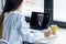 Back view of a doctor attending to a woman patient through a video call with the laptop at home