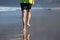 Back view of elderly mans legs running barefoot on wet sand