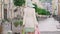 Back view of elegant stylish woman walking with shopping bags on sunny summer day outdoors. Camera follows charming