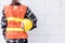 Back view of engineer, architect, supervisor worker wear reflective clothing for the safety of the work operation hold safety