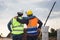 Back view of Engineer and foreman worker checking project at building site, Engineer and builders in hardhats in infrastructure