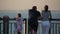 Back view of a family viewing the sea on the embankment.