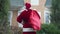 Back view Father Christmas with red bag walking to house scratching head thinking. Santa Clause in red costume with