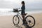 Back view female biker enjoying view of the Atlantic Ocean in Playa Honda beach, Canary Islands