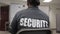 Back view of a female security guard listening to a man explaining a thing in front of a whiteboard