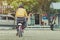 Back view of female teacher rides bicycle to teach students