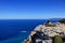 Back view of freedom man stand on rock cliff looking at blue sea and Cypriot nature. Contrast between midget and infinitely water