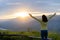 Back view. Freedom traveler teenage standing with raised arms and enjoying blue sky at sunset beautiful. Phu Pa PO or Fuji Loei of