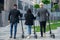 Back view of friendly multiracial office colleagues go to modern office building with electric scooters.