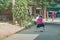 Back view of Girl student wear skirt to practice playing football alone on the street