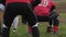 Back view of gridiron player snapping ball to teammate, amateur football game