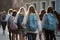 Back view of a group of female students with backpacks walking in the city, School students full rear view with school backpack,