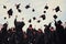 Back view of a group of graduates throwing mortarboards in the air, A group of graduates throwing graduation caps in the air, no