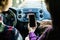 Back view of hands of young couple driving using navigation on mobile phone