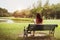 Back view of happy beauty woman in casual outfits using tablet in national park background. People lifestyles and technology