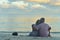 Back view. Happy elderly couple resting on tropical beach