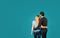 Back view Of Happy Embracing Couple With Copyspace On Blue Background.