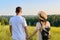 Back view, happy middle aged couple looking to horizon, nature summer background